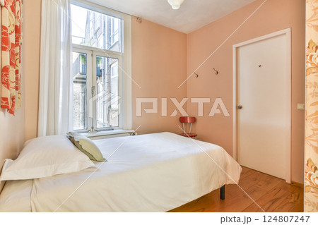 A serene bedroom featuring soft colors, a comfortable bed, and ample natural light streaming through a window, creating a peaceful atmosphere. A serene bedroom featuring soft colors, a comfortable bed, and ample natural light streaming through a window, creating a peaceful atmosphere. 124807247