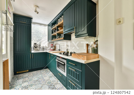 Stylish kitchen featuring sleek cabinets, open shelving, modern appliances, and patterned flooring. A bright and inviting culinary space with ample storage and functionality. 124807542