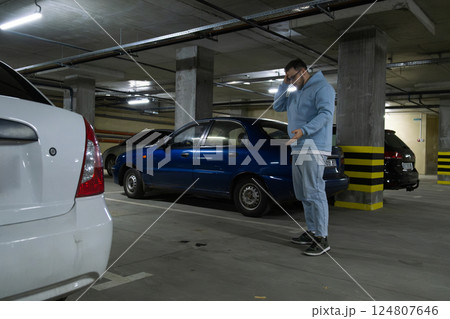 Person in Underground Parking Garage Figure Out of Stolen Car 124807646