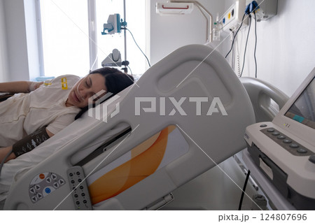 Patient Resting in Hospital Bed with Medical Equipment 124807696