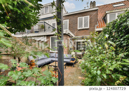 A serene backyard space featuring comfortable seating, surrounded by rich green plants, creating a perfect retreat for relaxation and gatherings. A serene backyard space featuring comfortable seating, surrounded by rich green plants, creating a perfect retreat for relaxation and gatherings. 124807729