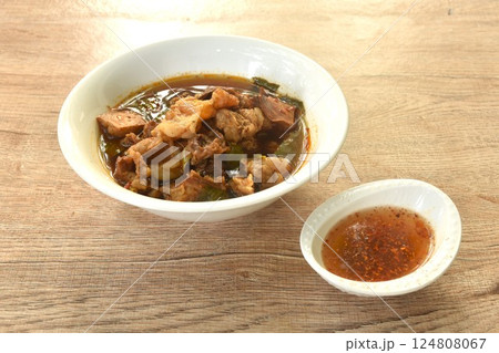 boiled braised beef meat and tendon in herb brown soup on bowl dipping spicy chili sauce  124808067
