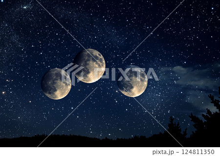 Three full moons shining brightly in a starry night sky 124811350