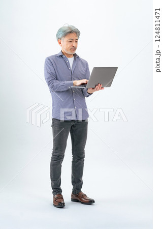 ノートパソコンを使うシニア男性の全身写真 ノートパソコンを使うシニア男性の全身写真 124811471