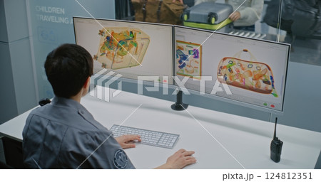 Female Security Officer Monitoring X-ray Scanning of Luggage on Computer Screens in Airport Female Security Officer Monitoring X-ray Scanning of Luggage on Computer Screens in Airport 124812351