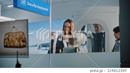 Woman During Screening Procedure. Computer Monitor Displaying Program of X-ray Scanning of Baggage Woman During Screening Procedure. Computer Monitor Displaying Program of X-ray Scanning of Baggage 124812397