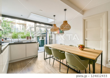 A sleek, modern kitchen featuring minimalistic design elements, natural light, and an inviting dining space with stylish seating. Perfect for contemporary living. A sleek, modern kitchen featuring minimalistic design elements, natural light, and an inviting dining space with stylish seating. Perfect for contemporary living. 124812433