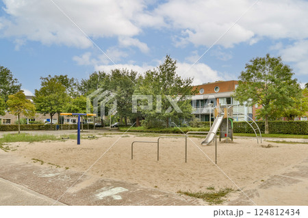 A quiet playground featuring a slide and workout bars surrounded by lush greenery and clear skies, inviting for leisure and activities. A quiet playground featuring a slide and workout bars surrounded by lush greenery and clear skies, inviting for leisure and activities. 124812434