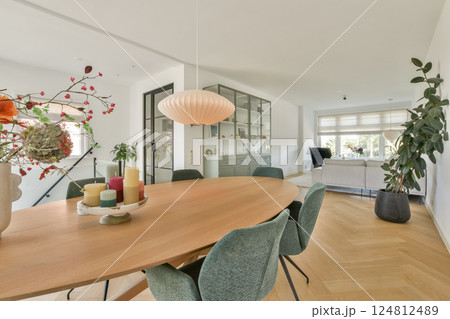 A stylish and inviting interior featuring a large wooden dining table, elegant decor, and vibrant plants, creating a warm and homey atmosphere. A stylish and inviting interior featuring a large wooden dining table, elegant decor, and vibrant plants, creating a warm and homey atmosphere. 124812489