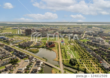 The image showcases a sprawling urban area featuring parks, pathways, and a river, highlighting a blend of nature and modern infrastructure. 124812509