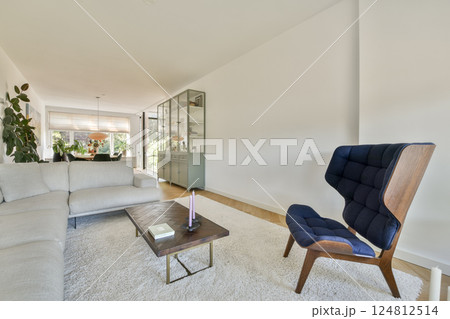 A stylish and contemporary living room featuring a comfortable sofa, elegant decor, and ample natural light, creating a cozy yet sophisticated atmosphere. 124812514