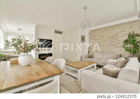 A stylish living room featuring a chic design with a cozy sofa, elegant chandelier, and tasteful decorative elements that create a welcoming atmosphere. A stylish living room featuring a chic design with a cozy sofa, elegant chandelier, and tasteful decorative elements that create a welcoming atmosphere. 124812570