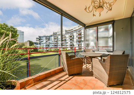 A stylish balcony featuring comfortable seating and an urban landscape. The design blends nature and contemporary living seamlessly. A stylish balcony featuring comfortable seating and an urban landscape. The design blends nature and contemporary living seamlessly. 124812575