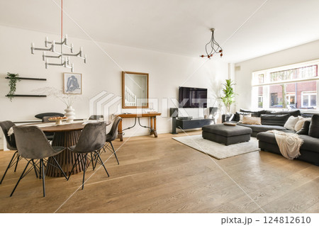 Spacious living room featuring contemporary furniture, a stylish dining area, and natural lighting, creating a warm and inviting atmosphere. 124812610