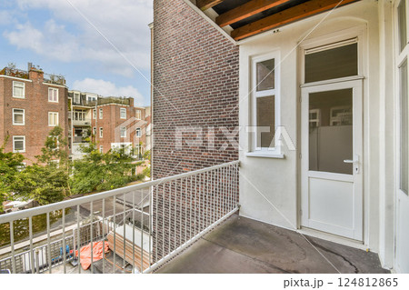 A contemporary balcony showcasing a blend of urban architecture with greenery visible from the outdoor space, highlighting a serene city atmosphere. 124812865