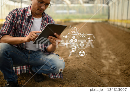 Modern farmer using digital tablet to access smart farming data 124813007