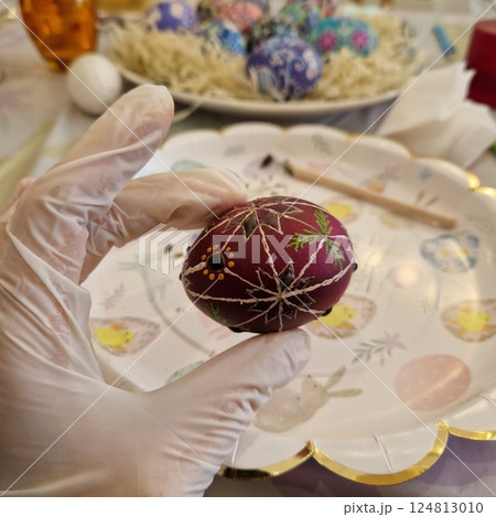 Crafting an Easter egg using traditional Ukrainian pysanka and beeswax technique, showcasing detailed folk patterns while celebrating cultural artistry and craftsmanship at Easter 124813010
