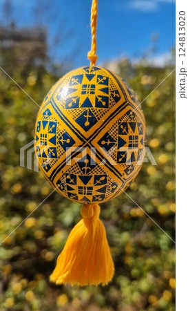 Vibrant traditional Ukrainian pysanka showcasing national colors yellow blue adorned with intricate patterns, celebrating Easter eggs and folk art traditions in a lively outdoor setting Vibrant traditional Ukrainian pysanka showcasing national colors yellow blue adorned with intricate patterns, celebrating Easter eggs and folk art traditions in a lively outdoor setting 124813020