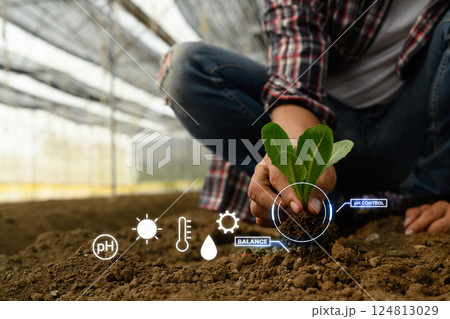 Farmer holding young seeding with with digital smart farming interface Farmer holding young seeding with with digital smart farming interface 124813029