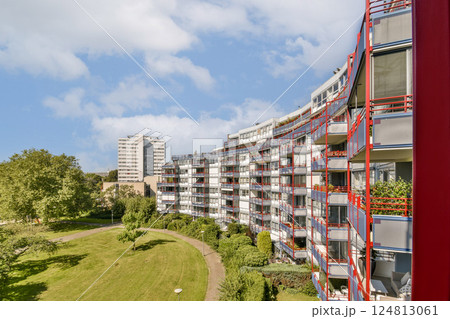 A vibrant view of contemporary residential buildings surrounded by greenery and blue skies, showcasing urban living harmoniously integrated with nature. A vibrant view of contemporary residential buildings surrounded by greenery and blue skies, showcasing urban living harmoniously integrated with nature. 124813061