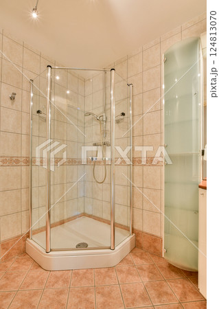 A sleek and modern shower stall featuring glass panels and elegant tile work. The spacious layout highlights contemporary bathroom aesthetics. 124813070