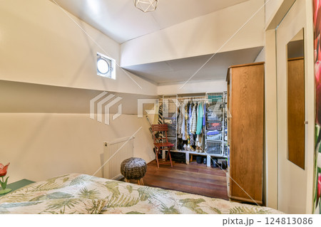 A cozy and well-organized bedroom interior showcasing elegant design elements and effective storage solutions for clothing and accessories. 124813086