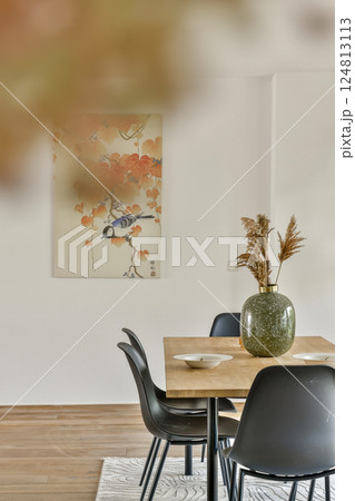 A stylish dining space featuring a beautifully arranged table and decorative wall art, combining modern design with artistic flair. A stylish dining space featuring a beautifully arranged table and decorative wall art, combining modern design with artistic flair. 124813113