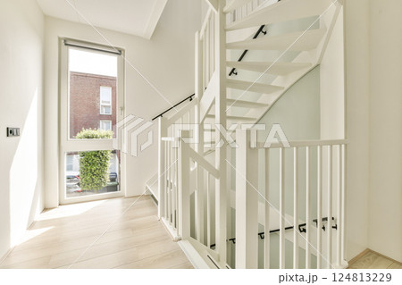 A bright, contemporary staircase in a well-lit interior featuring a sleek design and minimalist aesthetic. Perfect for showcasing modern architecture. 124813229
