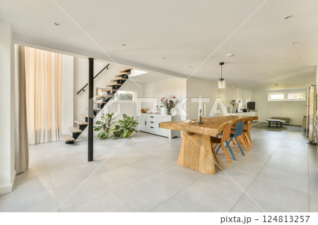 An inviting modern interior featuring a stylish staircase, well-furnished dining area, and bright natural light enhancing the space's appeal. An inviting modern interior featuring a stylish staircase, well-furnished dining area, and bright natural light enhancing the space's appeal. 124813257
