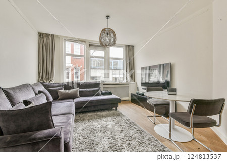 A contemporary living room showcasing elegant furniture, warm lighting, and a cozy atmosphere perfect for relaxation and socializing. A contemporary living room showcasing elegant furniture, warm lighting, and a cozy atmosphere perfect for relaxation and socializing. 124813537