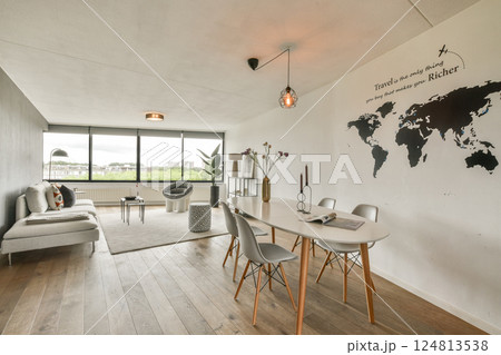 A sleek modern living space featuring a cozy sofa, elegant furniture, and a decorative world map on the wall, perfect for contemporary home decor enthusiasts. A sleek modern living space featuring a cozy sofa, elegant furniture, and a decorative world map on the wall, perfect for contemporary home decor enthusiasts. 124813538