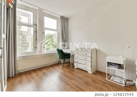 A spacious, minimalist bedroom featuring large windows, natural light, and a simple yet elegant decor with a desk and a comfortable armchair. A spacious, minimalist bedroom featuring large windows, natural light, and a simple yet elegant decor with a desk and a comfortable armchair. 124813543