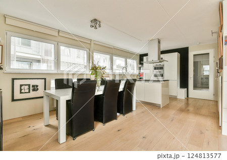 Contemporary kitchen design featuring large windows, sleek furniture, and a functional layout, creating a bright and inviting atmosphere for cooking and dining. 124813577