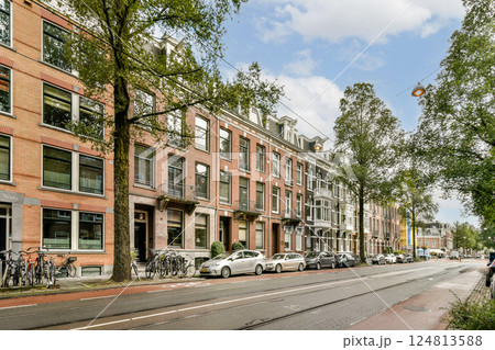 A picturesque urban street scene featuring historic buildings, green trees, parked bicycles, and cars under a clear sky, showcasing a blend of city life and nature. A picturesque urban street scene featuring historic buildings, green trees, parked bicycles, and cars under a clear sky, showcasing a blend of city life and nature. 124813588