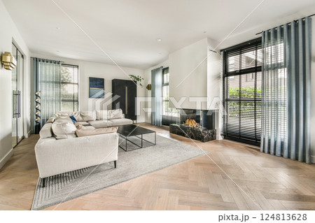 A stylish modern living room showcasing sleek furniture, abundant natural light, and elegant decor, creating a cozy yet sophisticated atmosphere. 124813628