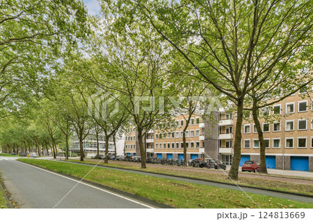 A peaceful path enveloped by lush greenery, lined with buildings and bicycles, illustrating a harmonious blend of nature and urban life. A peaceful path enveloped by lush greenery, lined with buildings and bicycles, illustrating a harmonious blend of nature and urban life. 124813669