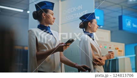 Two Beautiful Flight Attendants Talking, Waiting for Commercial Flight 124813706