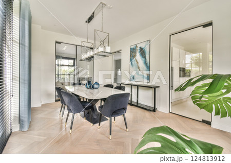 A stylish modern dining room featuring a sleek table, elegant chairs, and decor elements that enhance its contemporary appeal. 124813912