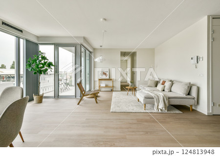 Bright and airy living room featuring minimalist decor, large windows, and a cozy seating arrangement. Perfect for relaxation and social gatherings. Bright and airy living room featuring minimalist decor, large windows, and a cozy seating arrangement. Perfect for relaxation and social gatherings. 124813948