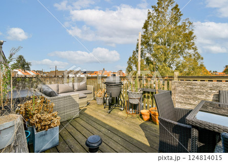 A beautifully arranged outdoor terrace featuring comfortable seating, a grill, and potted plants, perfect for relaxation and social gatherings. A beautifully arranged outdoor terrace featuring comfortable seating, a grill, and potted plants, perfect for relaxation and social gatherings. 124814015