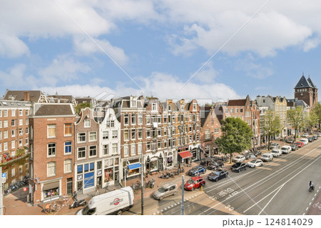 Charming streets lined with historic buildings, cafes, and trees create a picturesque cityscape in Amsterdam. A blend of modern life and historical beauty. 124814029