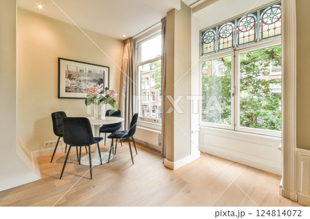 An elegantly designed room featuring minimalist furniture and natural light streaming through large windows, creating a serene atmosphere. 124814072