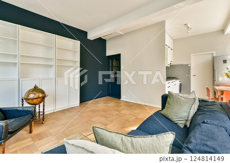 A stylish modern interior showcasing minimalist design elements with a cozy seating area and open layout, featuring neutral colors and natural light. 124814149