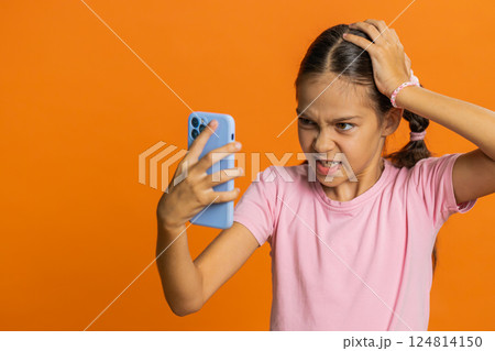 Upset sad child girl use smartphone play game loses loss fail unlucky news bad lottery result crisis 124814150