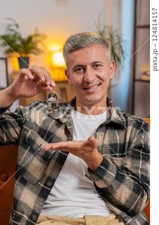 Young man real estate agent showing the keys of new home house apartment, buying, renting property Young man real estate agent showing the keys of new home house apartment, buying, renting property 124814157