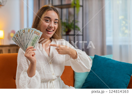 Successful rich happy smiling woman holding waving dollar bill money fan winning online lottery game Successful rich happy smiling woman holding waving dollar bill money fan winning online lottery game 124814163