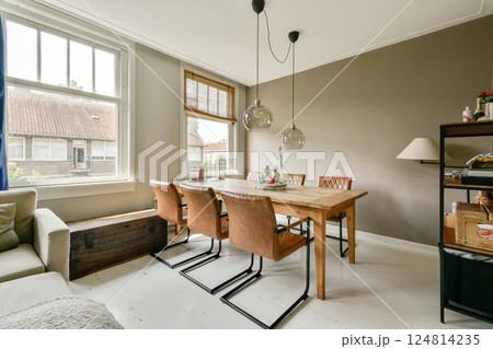 A cozy dining area featuring stylish furniture, large windows, and hanging pendant lights creating a warm atmosphere. Perfect for gatherings and everyday use. A cozy dining area featuring stylish furniture, large windows, and hanging pendant lights creating a warm atmosphere. Perfect for gatherings and everyday use. 124814235