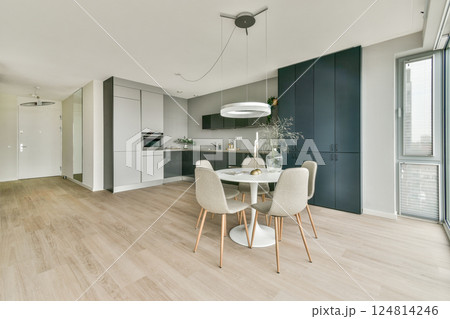 A contemporary kitchen featuring clean lines, a round dining table, stylish chairs, and a mix of light and dark cabinetry, emphasizing functionality and aesthetics. A contemporary kitchen featuring clean lines, a round dining table, stylish chairs, and a mix of light and dark cabinetry, emphasizing functionality and aesthetics. 124814246