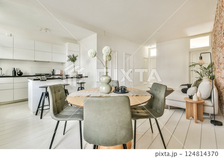 A sleek and contemporary living space featuring a stylish dining area, ergonomic furniture, and elegant decor that emphasizes simplicity and functionality. A sleek and contemporary living space featuring a stylish dining area, ergonomic furniture, and elegant decor that emphasizes simplicity and functionality. 124814370