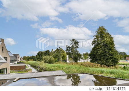 A contemporary building design harmoniously integrated with lush greenery and clear skies, showcasing a balance between architecture and natural beauty. A contemporary building design harmoniously integrated with lush greenery and clear skies, showcasing a balance between architecture and natural beauty. 124814373